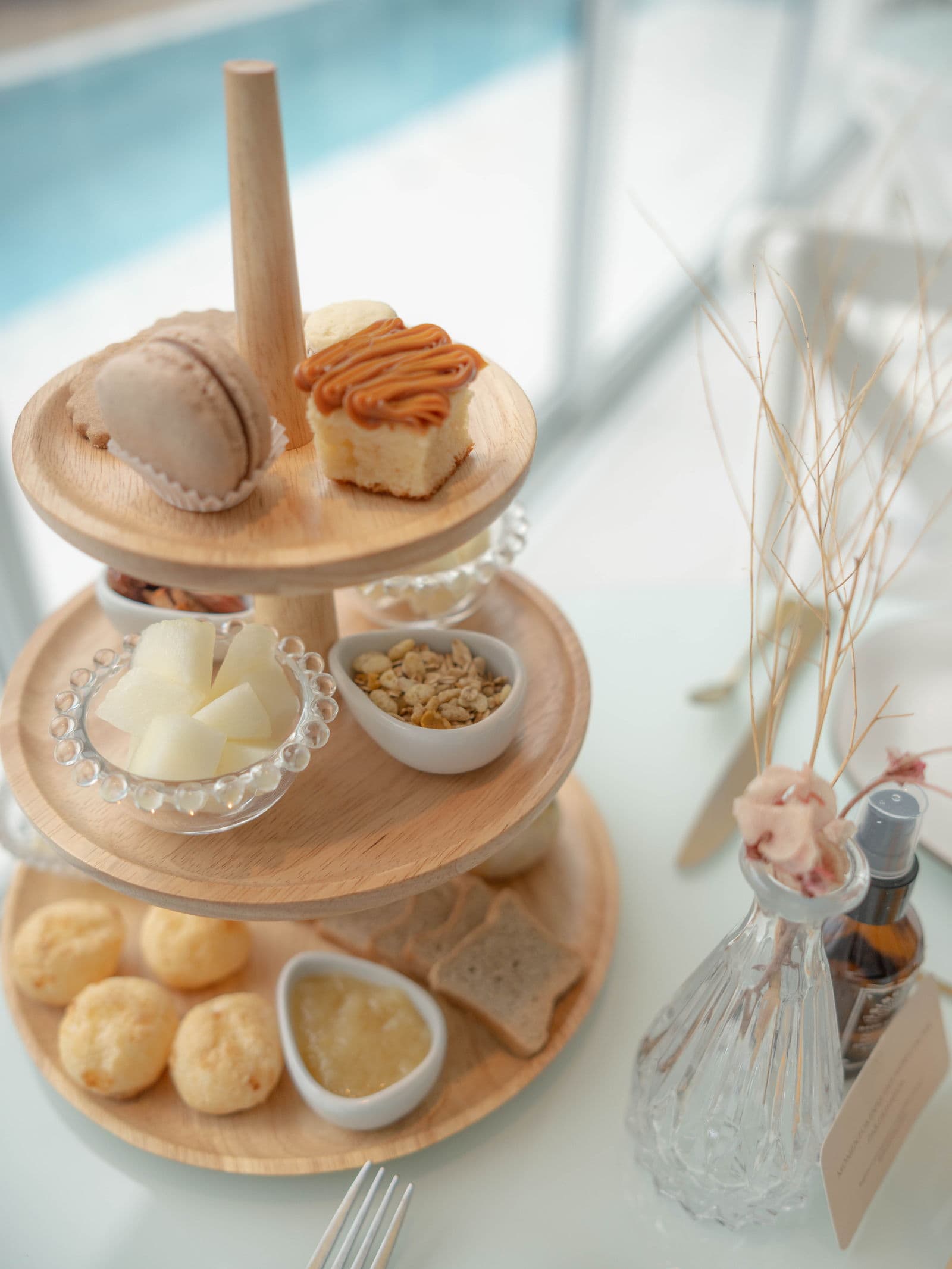 Detalhe da torre de café da manhã com macaron, bolo de doce de leite, frutas e pães de queijo